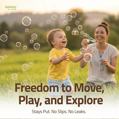 Toddler running through field chasing bubbles with mother, showing freedom of movement with Natissy potty training pads that stay put with no slips or leaks